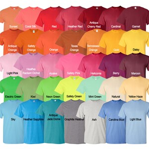 Puede incluir: Una tabla de 30 camisetas de diferentes colores, cada una con un nombre impreso debajo. Los colores incluyen puesta de sol, seda coral, rojo, rojo jaspeado, rojo cereza antiguo, cardenal, granate, naranja antiguo, naranja de seguridad, naranja, naranja de Texas, naranja de Tennessee, dorado, margarita, rosa claro, orqu&iacute;dea radiante jaspeada, azalea, rosa de seguridad, heliconia, baya, marr&oacute;n, verde el&eacute;ctrico, kiwi, verde ne&oacute;n, verde de seguridad, verde menta, natural, neblina amarilla, cielo, zafiro jaspeado, c&uacute;pula de jade antiguo, gris jaspeado, ceniza, azul de Carolina y azul claro.