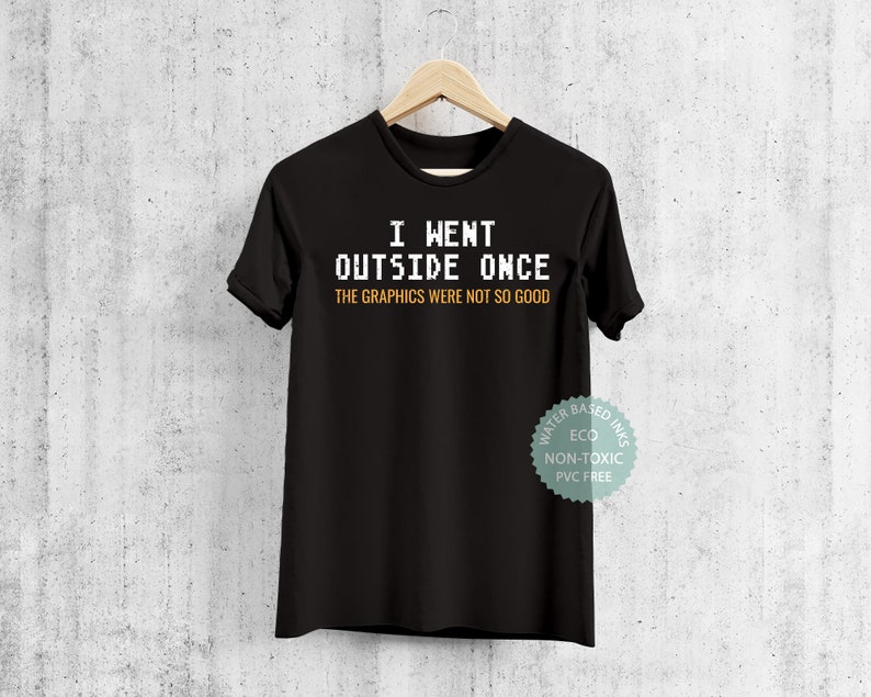 May include: Black t-shirt with white text that reads "I went outside once the graphics were not so good". The shirt has a tag that says "Water Based Inks Eco Non-Toxic PVC Free".