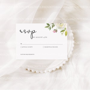 May include: White RSVP card with a floral design in the top right corner. The card has a section for guests to indicate whether they will be attending the event by August 15th. The card also includes a section for dietary requirements.