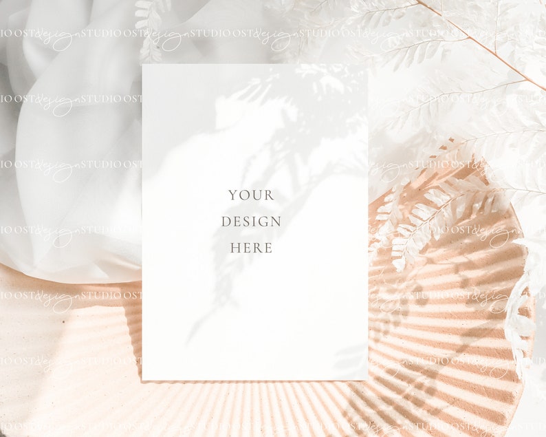 May include: A white card with the text "YOUR DESIGN HERE" on a light brown background with a white floral shadow.