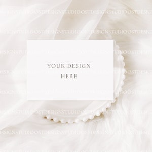 May include: A white card with the text "YOUR DESIGN HERE" on a white background with a white beaded plate.