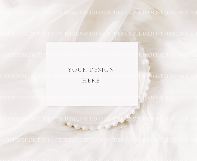 May include: A white card with the text "YOUR DESIGN HERE" on a white background with a white beaded plate.