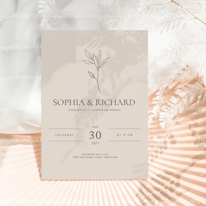 May include: A minimalist wedding invitation with a beige background and a simple line drawing of a branch with leaves. The text reads "Sophia & Richard" and includes the date and time of the wedding: "Saturday, August 30, 2021 at 4 PM". The invitation also includes the location: "Westwood Golf Club, 1000 Inglewood Street, Vancouver."
