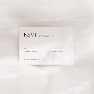 Op de afbeelding: Een witte RSVP-kaart met zwarte tekst. De kaart heeft twee keuzerondjes voor gasten om "Met plezier accepteert" of "Helaas afwijzen" te selecteren. De kaart bevat ook een ruimte voor dieetwensen.