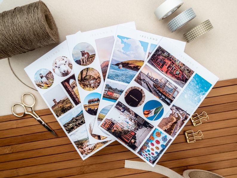 May include: Four sheets of stickers featuring images of Ireland. The stickers are round and rectangular and feature images of sheep, a lighthouse, a thatched roof cottage, a harbor, a city street, and a pub. The stickers are on a white background.