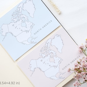 May include: Two cards with North America maps, one light blue and one pale pink, are displayed open in a notebook. The maps are outlined in black. The text "NORTH AMERICA" is printed on each card. The cards measure 3.54 x 4.92 inches.