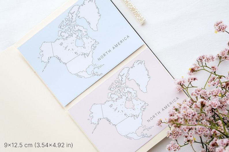 May include: Two cards with North America maps, one light blue and one pale pink, are displayed open in a notebook. The maps are outlined in black. The text "NORTH AMERICA" is printed on each card. The cards measure 3.54 x 4.92 inches.