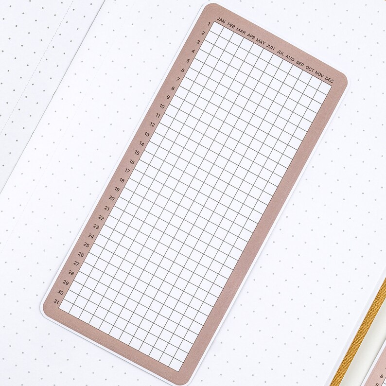 May include: A brown and white calendar tracker with a grid of 31 squares and the months of the year listed across the top.