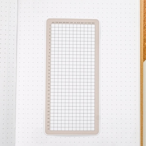 May include: A beige monthly calendar sticker with a grid layout and the months of the year listed across the top. The numbers 1 through 31 are listed down the left side.
