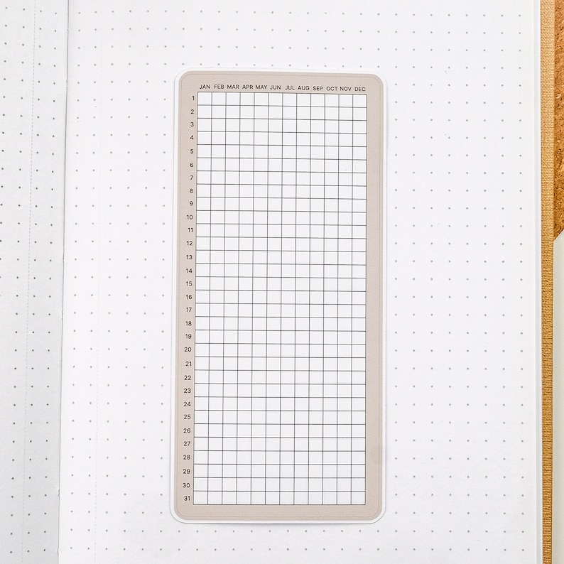 May include: A beige monthly calendar sticker with a grid layout and the months of the year listed across the top. The numbers 1 through 31 are listed down the left side.