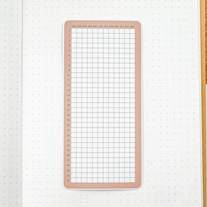 May include: A printable calendar sticker with a grid layout for each month of the year. The sticker is peach colored with black text and lines. The months are labeled: January, February, March, April, May, June, July, August, September, October, November, December. The days of the month are numbered 1 through 31.