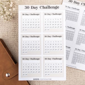 May include: Six beige printable 30-day challenge calendar stickers with black text. Each sticker has a grid with numbers 1 through 30.