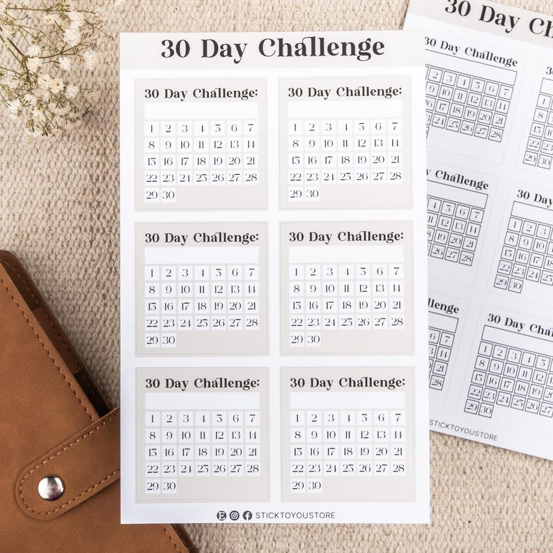 May include: Six beige printable 30-day challenge calendar stickers with black text. Each sticker has a grid with numbers 1 through 30.
