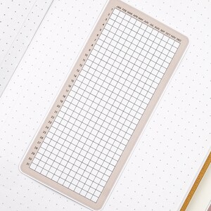 May include: A beige printable calendar with a grid of 31 days and 12 months, labeled January through December. The calendar is designed for use with a planner or bullet journal.
