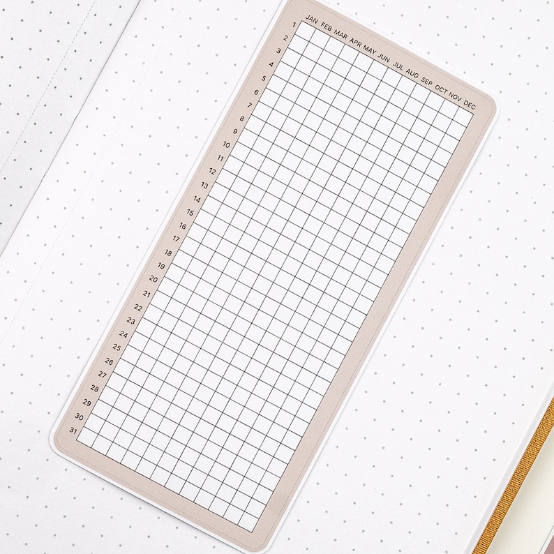 May include: A beige printable calendar with a grid of 31 days and 12 months, labeled January through December. The calendar is designed for use with a planner or bullet journal.