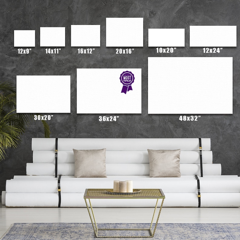 May include: A white couch with a gold metal coffee table in front of it. The wall behind the couch has a display of different sized white canvases with dimensions listed in inches. The canvas labeled "MOST POPULAR" is 36 inches by 24 inches.