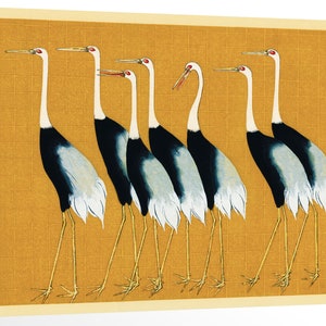 May include: A vintage Japanese woodblock print depicting seven red-crowned cranes standing in a row on a gold background. The cranes are facing different directions and have long necks and legs. The print is framed in a cream-colored border.