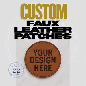 May include: A brown, circular faux leather patch with the text "YOUR DESIGN HERE". The image also features the text "CUSTOM FAUX LEATHER PATCHES" in gold and black, and a logo for "The Eleven 22 Studio".