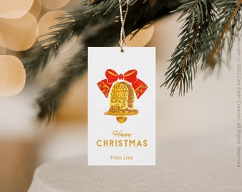 Pode incluir: Uma etiqueta de presente branca com uma ilustração de um sino dourado e um laço vermelho. O texto "Feliz Natal" e "De Lisa" está impresso em letras douradas.