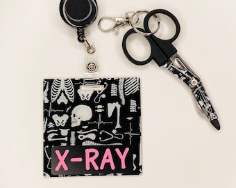 May include: Black and white patterned badge holder with a pink "X-RAY" label, a black retractable badge reel, and a black and white patterned surgical scissors.