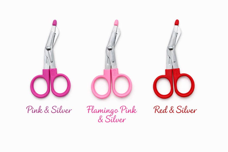 May include: Three medical shears with silver blades and colored handles. The handles are pink, light pink, and red. Text below reads "Pink & Silver", "Flamingo Pink & Silver", and "Red & Silver".
