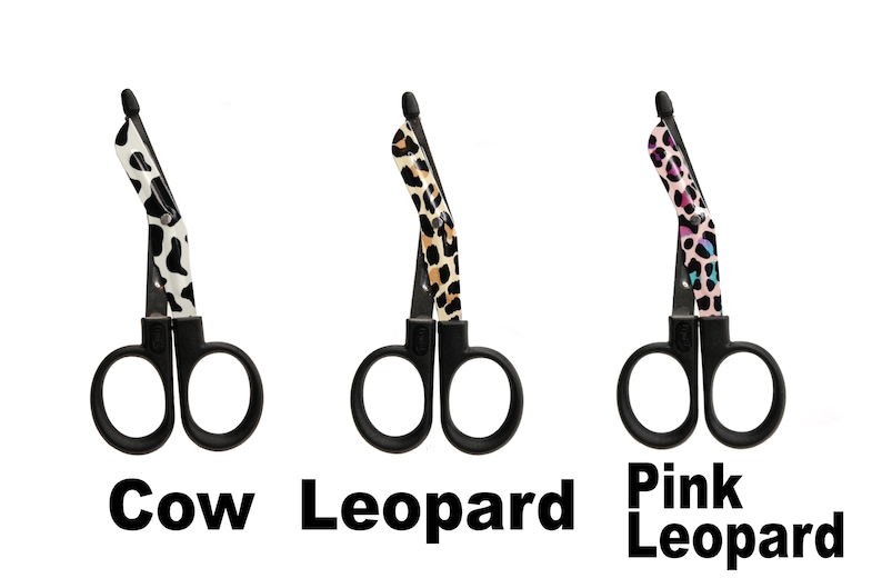 May include: Three pairs of black medical shears with patterned handles. The patterns include cow print, leopard print, and pink leopard print. The text "Cow", "Leopard", and "Pink Leopard" are below each pair of shears.