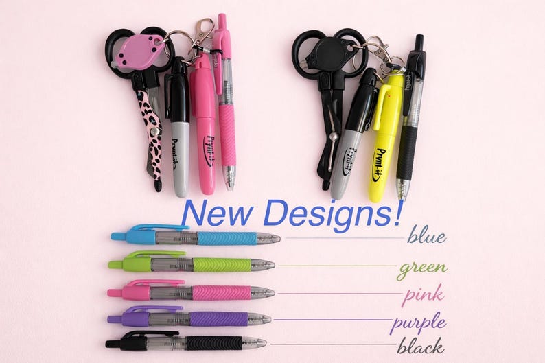 May include: An assortment of pens and keychains are displayed against a light pink background. The pens come in blue, green, pink, purple, and black. The text "New Designs!" is visible.