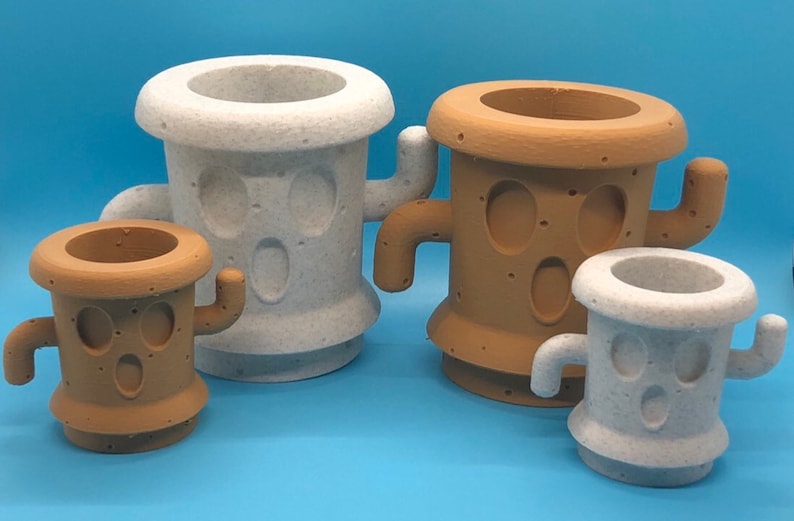 May include: Four different sized cactus-shaped planters, two are white and two are brown. The planters have a face with two eyes and a mouth.