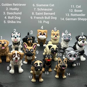 May include: A collection of 14 small, colorful figurines of dogs and cats. The figurines are numbered 1 through 14, with each number corresponding to a different breed of dog or cat. The figurines are arranged in a circle on a black surface.