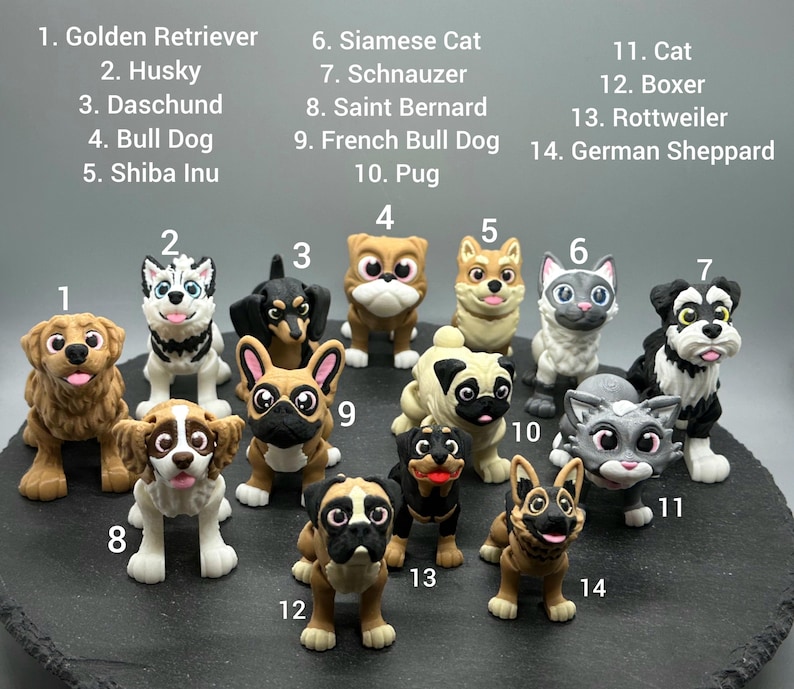 May include: A collection of 14 small, colorful figurines of dogs and cats. The figurines are numbered 1 through 14, with each number corresponding to a different breed of dog or cat. The figurines are arranged in a circle on a black surface.