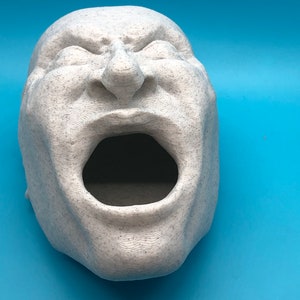 May include: A white, textured, 3D printed sculpture of a face with an open mouth. The sculpture is a realistic depiction of a person screaming.