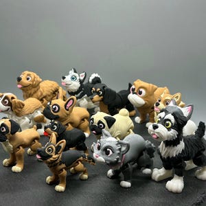 May include: A collection of 13 small, colorful, plastic figurines of dogs and cats. The figurines are in various poses and have realistic details.