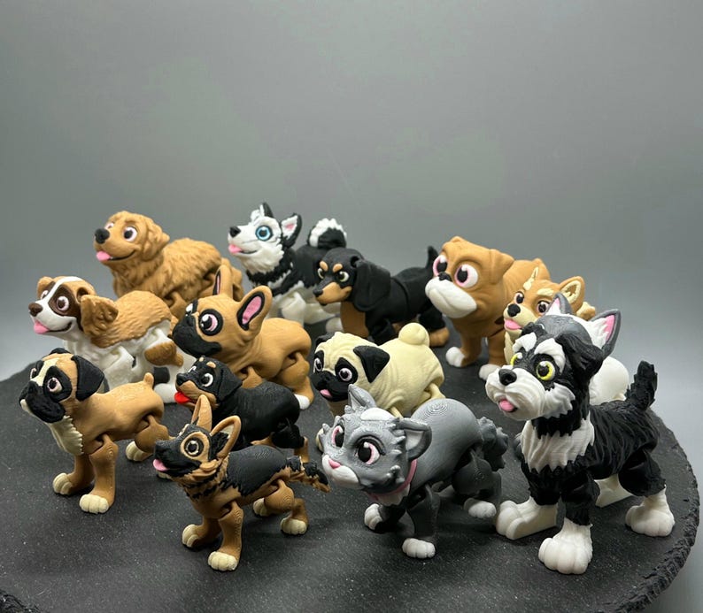 May include: A collection of 13 small, colorful, plastic figurines of dogs and cats. The figurines are in various poses and have realistic details.