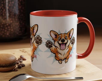 Puede incluir: Taza de cerámica blanca con interior y asa rojos. La taza presenta un diseño de corgi de dibujos animados con las patas en alto y la lengua fuera. El diseño está sobre un fondo de estrella azul claro.