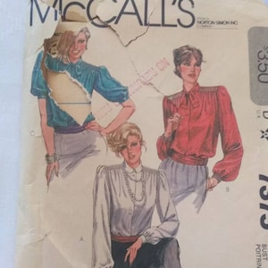 May include: Vintage McCall's sewing pattern for a blouse, featuring three different styles. The pattern number is 7375 and the size is 12. The pattern is printed on a white background with a red, white, and blue border.