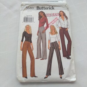 Könnte beinhalten: Ein Nähmusterumschlag für Damenhosen. Das Muster ist für die Größen 12, 14 und 16. Der Umschlag zeigt vier verschiedene Hosenmodelle, darunter eine braune Hose, eine gestreifte Hose, eine graue Hose und eine burgunderfarbene Hose. Das Muster ist von Butterick.