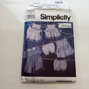 May include: Simplicity sewing pattern number 7809 for sizes BB (2-4). The pattern includes instructions for making a dress and bloomers. The pattern is for a classic heirloom style. The pattern is illustrated with a line drawing of a dress and bloomers hanging on a clothesline.