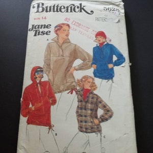 May include: A vintage sewing pattern envelope for a hooded jacket. The pattern is by Butterick and is for size 14. The envelope features four different styles of the jacket, including a red, blue, tan, and plaid version. The text on the envelope reads "Butterick 5628, Jane Tise, No Exchange or Return on Textiles."