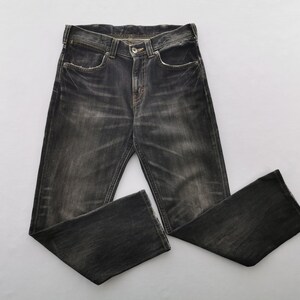 May include: Dark gray denim jeans with a faded wash. The jeans have a classic five-pocket design, a button and zipper closure, and a straight leg. The fabric appears worn and distressed.