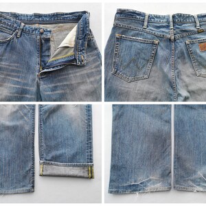 May include: Four-panel image of light blue denim jeans. The jeans are faded and worn, with a button and zipper closure. The back pockets have a classic design, and a leather patch with the brand name is visible. The bottom of the jeans are frayed.