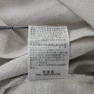 Peut inclure: Gros plan sur un tissu blanc avec une &eacute;tiquette cousue. L'&eacute;tiquette contient du texte japonais et le num&eacute;ro "2600-2360-025". Le tissu est l&eacute;g&egrave;rement froiss&eacute;.