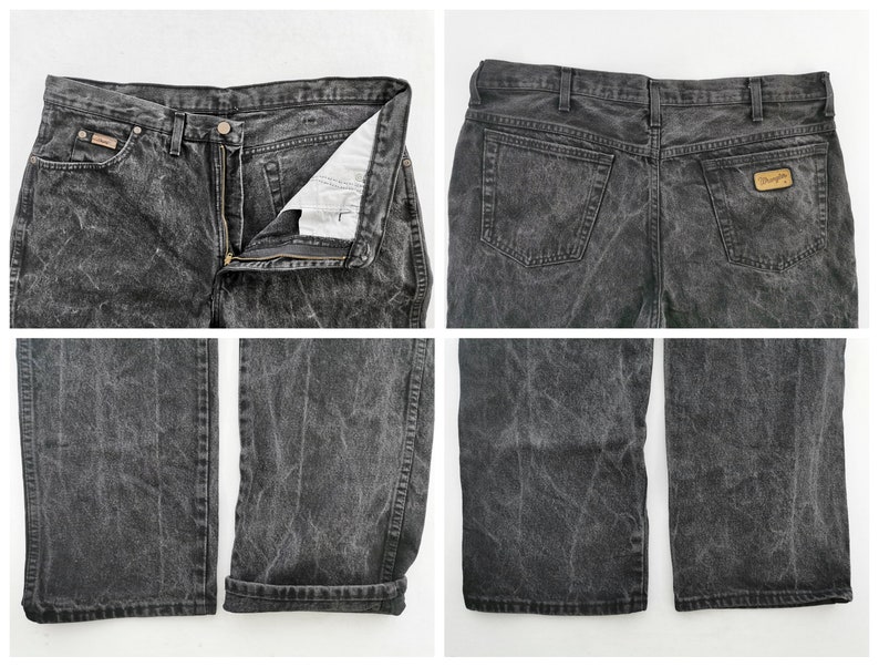 May include: A pair of acid-wash black denim jeans. The jeans have a button and zipper closure, front and back pockets, and a Wrangler brand patch. The jeans are shown from multiple angles, including front, back, and close-up views of the legs.
