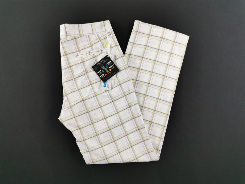 Op de afbeelding: Witte geblokte broek met een geel label met de tekst "WICKED"