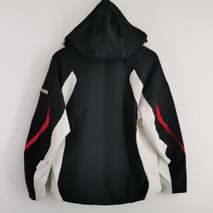 Pode incluir: Casaco preto com capuz com detalhes em branco e vermelho. O casaco apresenta um corpo preto, pain&eacute;is laterais brancos e riscas vermelhas. A palavra "win" &eacute; vis&iacute;vel na manga esquerda. Vestu&aacute;rio exterior pr&aacute;tico.