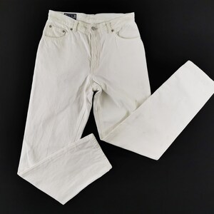 May include: Off-white denim jeans with a classic five-pocket design. The jeans have a button and zipper closure, belt loops, and a straight leg fit. The garment is made of a sturdy cotton blend and is suitable for casual wear.