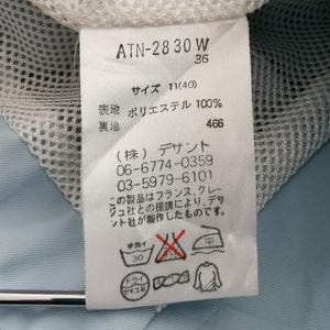 May include: A white clothing tag with Japanese text and care symbols. The tag includes the text "ATN-28 30 W" and "36". The tag also has washing instructions and the text "ポリエステル 100%" which translates to "Polyester 100%"