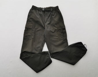 Puede incluir: Pantalones cargo de color gris carbón oscuro con tejido texturizado, cintura elástica con cinturón de hebilla ajustable integrado, dos bolsillos cargo laterales con solapa y cierres de cordón ajustables en los bajos.