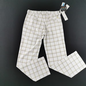 Op de afbeelding: Witte geblokte broek met een lichtbruin en geel ruitpatroon.