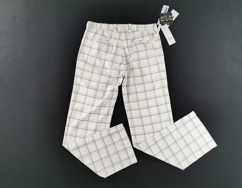 Op de afbeelding: Witte geblokte broek met een lichtbruin en geel ruitpatroon.