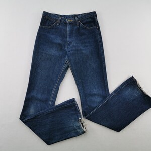 Peut inclure: Jean bleu fonc&eacute; &agrave; taille haute et jambe &eacute;vas&eacute;e. Le jean a une conception classique &agrave; cinq poches et une fermeture boutonn&eacute;e et zipp&eacute;e. L'ourlet du jean est effiloch&eacute;.